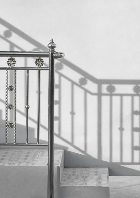 stainless-steel-handrail-of-vintage-outdoor-staircase-with-sunlight-and-shadow-on-cement-wall-1024x682